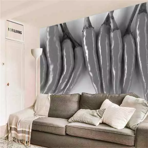 Sofa im Wohnzimmer vor einer Wand mit großem Schwarz-Weiß-Muster von Chillischoten