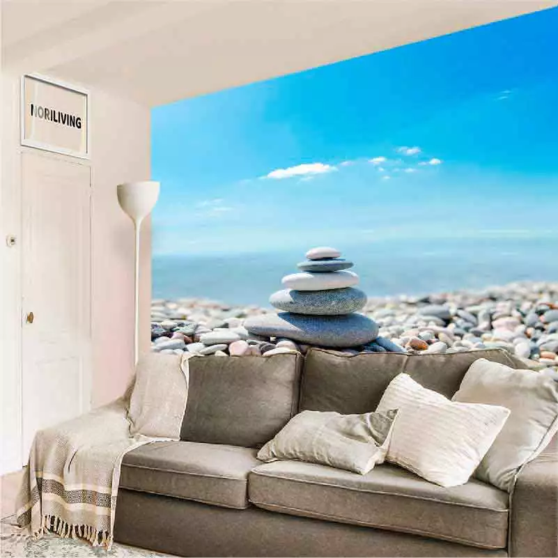 Wohnzimmer mit gemütlichem Sofa, das von einer großen Fototapete mit Meeresblick und dekorativen Steinen an der Wand ergänzt wird