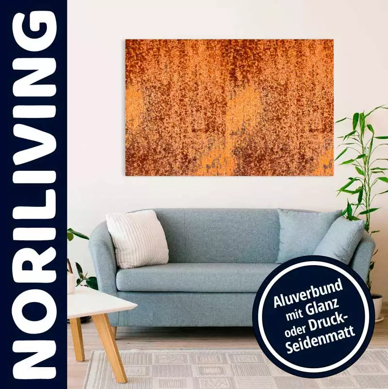 Ein Wohnzimmer mit einem blauen Sofa und einem abstrakten Kunstwerk an der Wand. Links unten ist ein Tisch zu sehen, daneben eine Pflanze, und auf der rechten Seite steht ein weiteres Kissen.