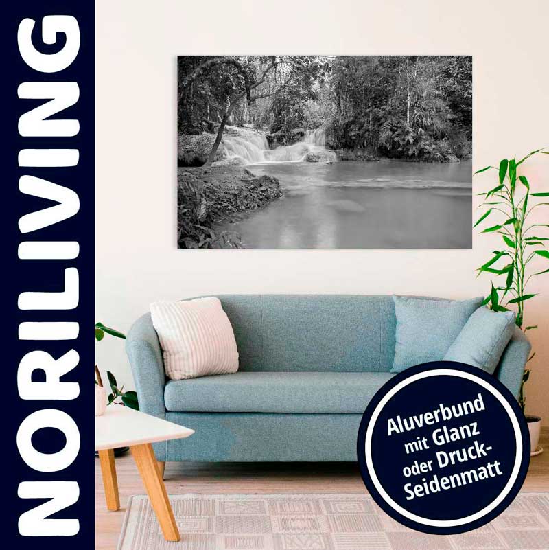 Helles Wohnzimmer mit Aluverbund-Wandbild eines Wasserfalls über einem hellblauen Sofa, Pflanze und Holztisch