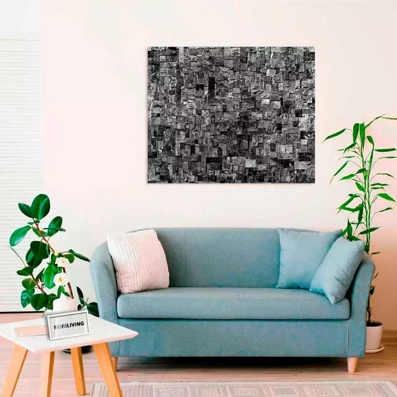 Modernes Wohnzimmer mit blauem Sofa, Pflanzen und einem abstrakten schwarz-weißen Wandbild