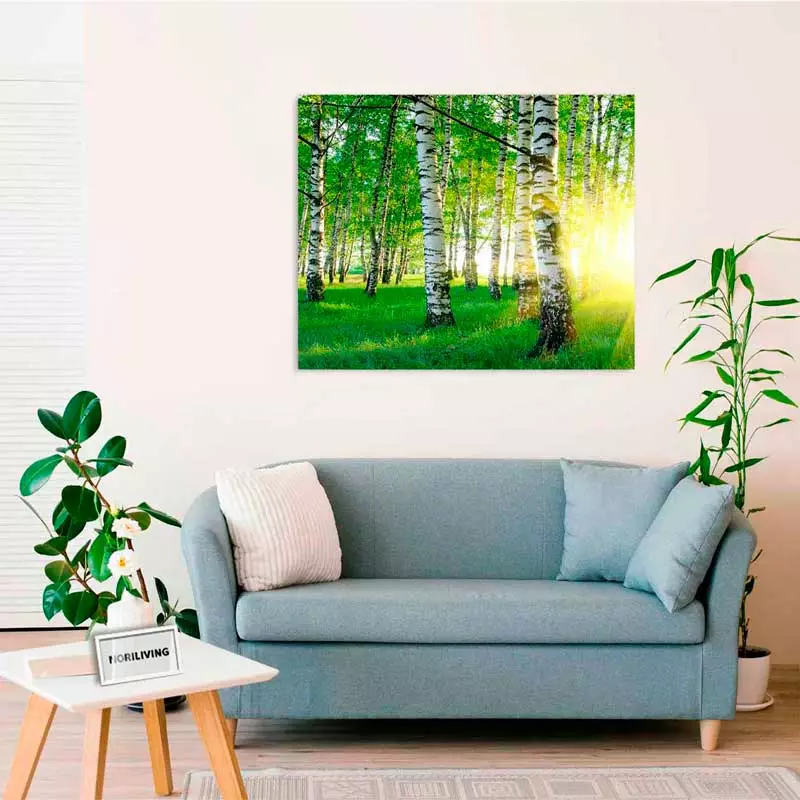 Ein helles Wohnzimmer mit einem hellblauen Sofa, dekorativen Kissen und einem Wandbild, das einen sonnigen Birkenwald zeigt.