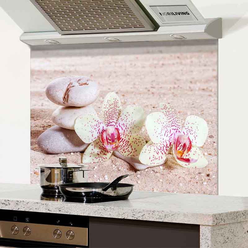 Küchenspritzschutz mit Orchideen und Steinen auf Sandhintergrund über einem Herd