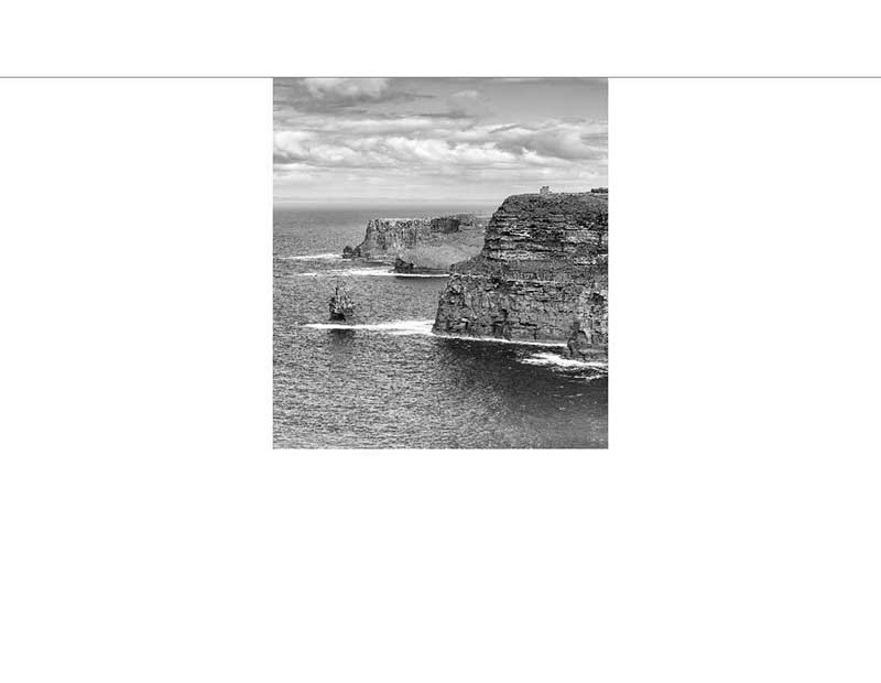 Schwarz-Weiß-Foto von mächtigen Klippen, die aus dem Meer ragen