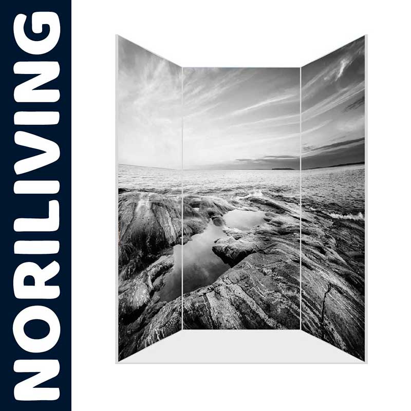 Fototapete zeigt eine beeindruckende Küstenlandschaft in Schwarz-Weiß mit Felsen im Vordergrund und Meer im Hintergrund, hergestellt von NORILIVING