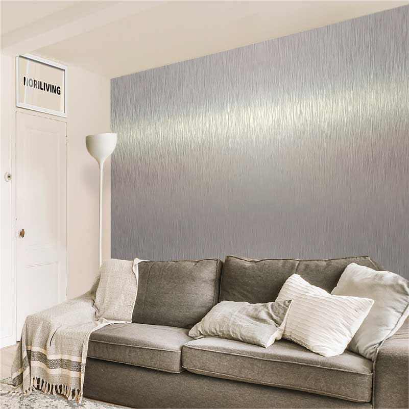 Gemütliches graues Ecksofa mit Kissen vor einer stilvollen geriffelten Tapete in einem modernen Wohnzimmer mit Stehlampe