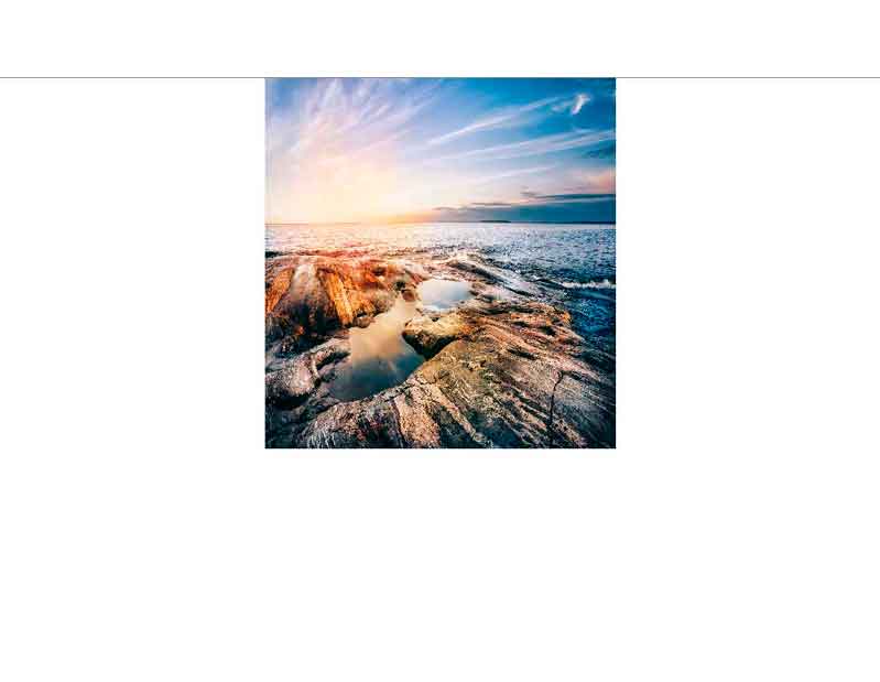 Landschaftlicher Ausblick auf eine sonnige Küste bei Sonnenuntergang Felsige Küste mit Wasserlachen im Vordergrund und einem leuchtenden Sonnenuntergang im Hintergrund