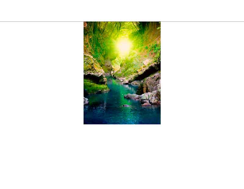 Lichtdurchflutete Schlucht mit glasklarem Fluss Sonnenlicht erhellt eine grüne Schlucht mit einem ruhigen, klaren Fluss inmitten von Felsen und Bäumen.