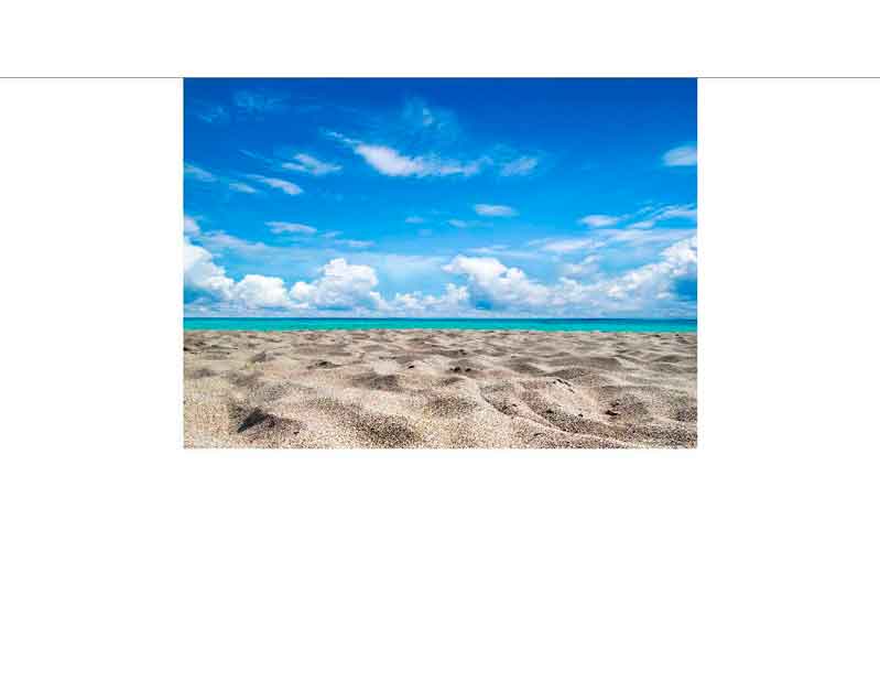 Sandstrand vor klarem, blauem Himmel mit Wolken