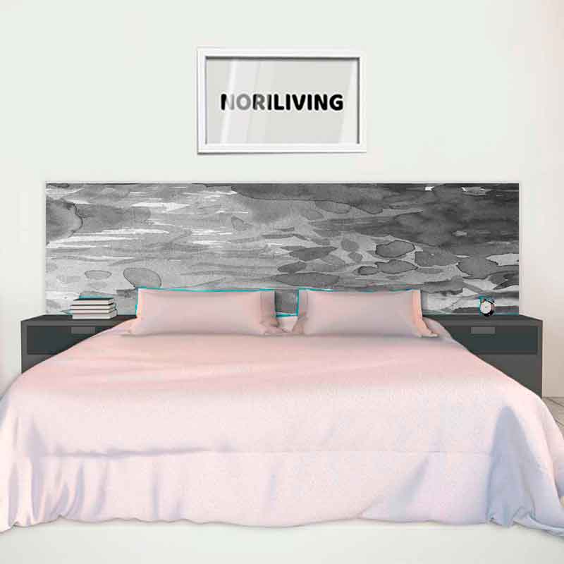 Ein gemütliches Doppelbett mit grauem, künstlerischem Betthaupt und Nachttischen, darüber ein gerahmtes Bild mit der Aufschrift 'NORILIVING'.