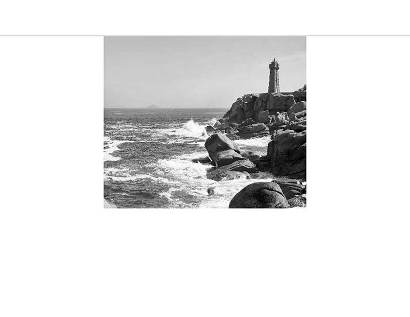 Schwarzweißbild eines Leuchtturms auf einer Felsküste mit dem Ozean im Hintergrund