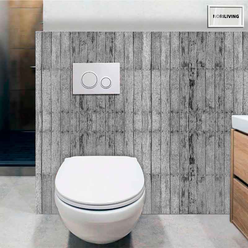 Wandhängende Toilette mit Doppelspülung vor einer Wand mit grauen Holzpaneelen