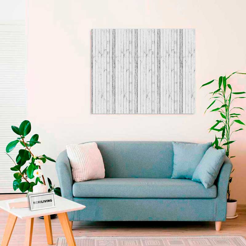 Ein stilvoll eingerichtetes Wohnzimmer mit einer blauen Couch, Pflanzen und einer Wanddekoration aus Holzlatten.