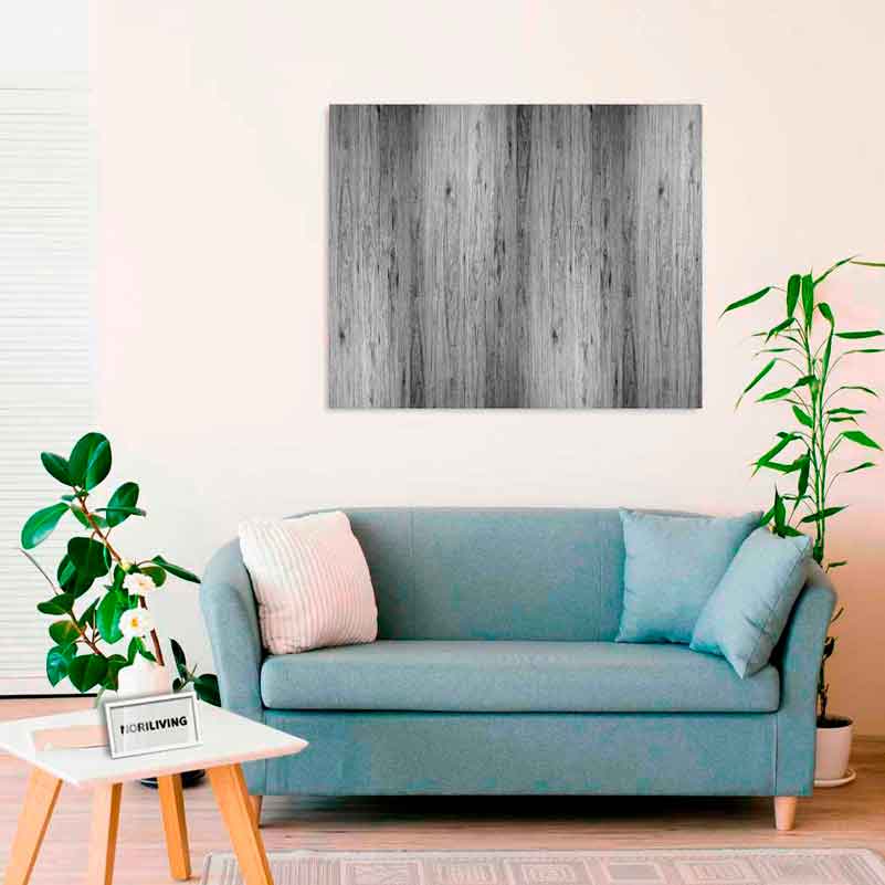 Ein helles Wohnzimmer mit einer blauen Couch, einem Holzkunstwerk an der Wand und Pflanzen.