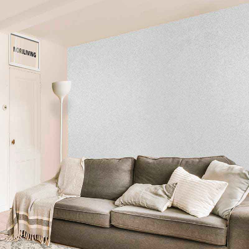 Gemütliches Wohnzimmer mit grauem Sofa, weißen Kissen und Stehlampe