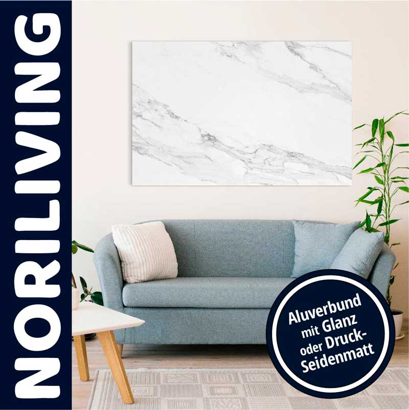 Helles Wohnzimmer mit einem eleganten blauen Sofa, Dekokissen und einem großen Wandbild aus Aluverbund mit Marmoroptik, umgeben von Pflanzen.