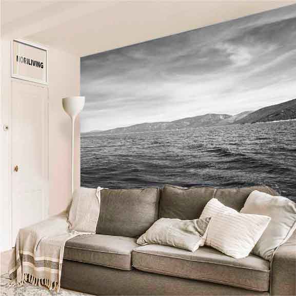 Modernes Wohnzimmer mit grauem Sofa und einer großen, schwarz-weißen Wandtapete mit Landschaftsmotiv.