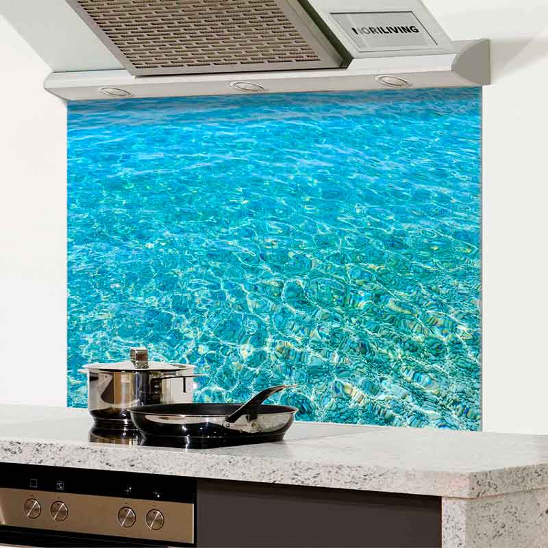 Glasrückwand mit Wasser-Motiv für die Küche Modern gestaltete Küche mit Glasrückwand, die ein realistisches Wasser-Motiv zeigt, ergänzt durch Dunstabzugshaube und kochendes Geschirr auf der Arbeitsplatte.