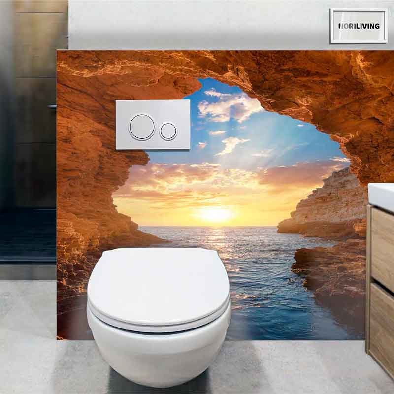 Moderne Toilette mit Landschaftstapete: Sonnenuntergang über dem Meer durch ein Felsenportal
