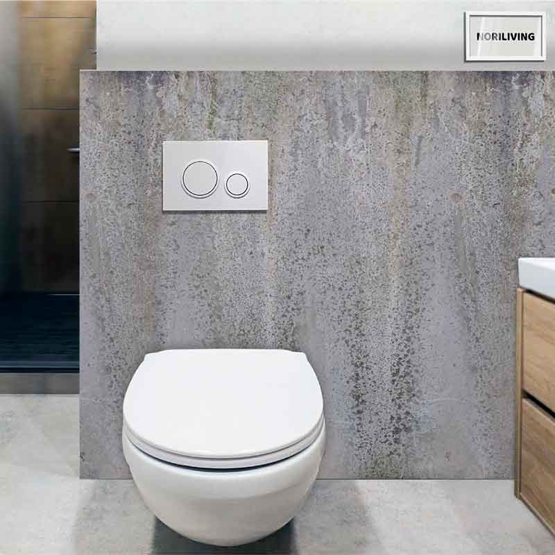 Ein modernes, wandmontiertes WC mit einer zweifachen Spültaste, eingebaut in eine minimalistische Badezimmerwand vor Betonoptik.