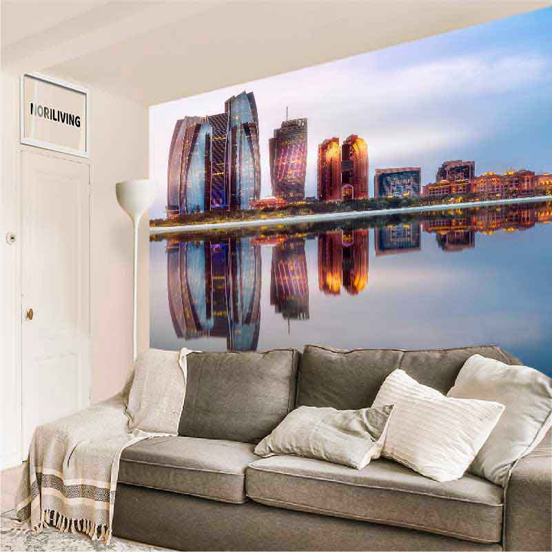 Gemütliches Wohnzimmer mit grauem Sofa und großflächiger Wandtapete, die eine beleuchtete Stadt bei Nacht zeigt.