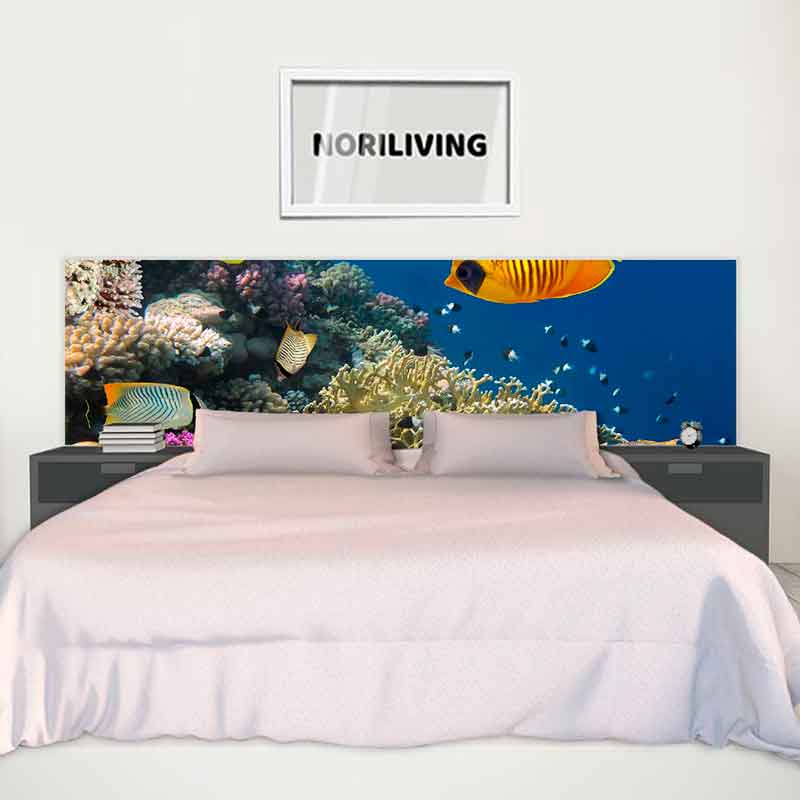 Ein Bett mit einem Kopfteil, das ein buntes Unterwasser-Korallenriff zeigt, darüber ein Bild mit der Aufschrift NORILIVING.