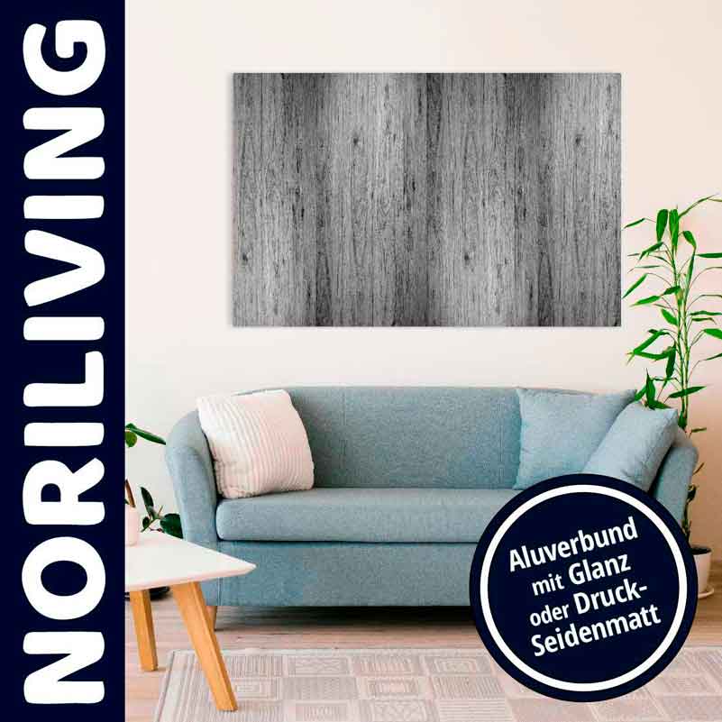 Helles Wohnzimmer mit blauer Couch und Wandbild in Holzoptik, Pflanzen im Hintergrund