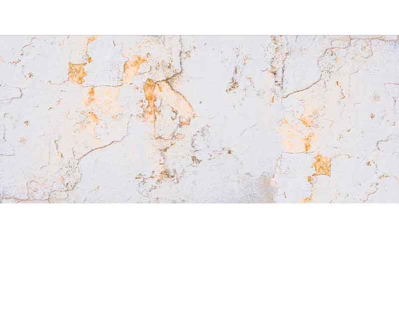 Eine alte, abblätternde Wand mit verschiedenen Farbschichten und Texturen