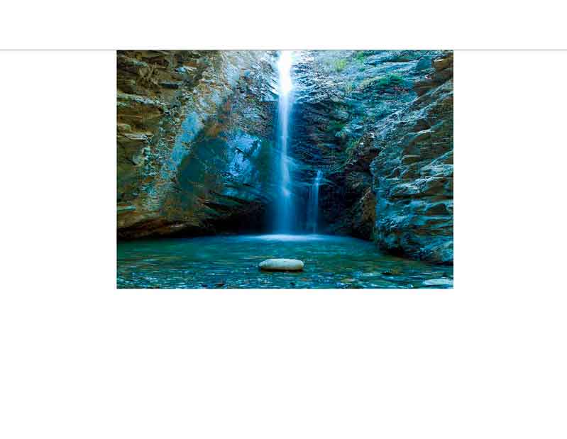 Ein ruhiger Wasserfall fließt in einem abgelegenen Canyon in ein klares Becken.