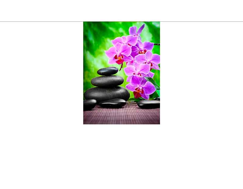 Ein Stapel aus Zen-Steinen neben blühenden lila Orchideen auf einer Stoffmatte, umgeben von grünem Hintergrund