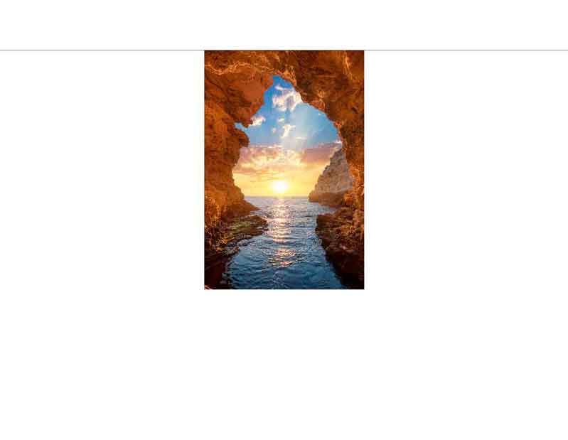 Sonnenuntergang durch eine Felsformation am Meer Blick aus einer Höhle auf einen Sonnenuntergang über dem Meer mit bewölktem Himmel und ruhigem Wasser