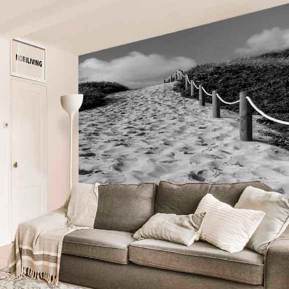 Wohnzimmer mit grauem Sofa und Tapete eines Strandwegs in Schwarz-Weiß