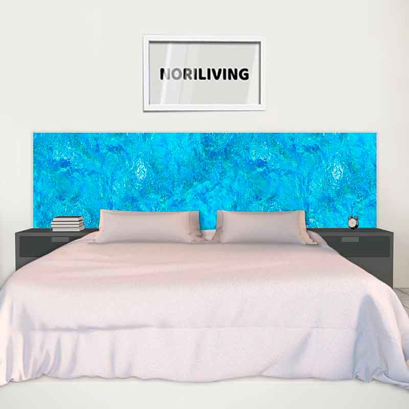 Schlafzimmer mit blauem Kopfteil, Bett mit weißen Kissen und gerahmtem Bild