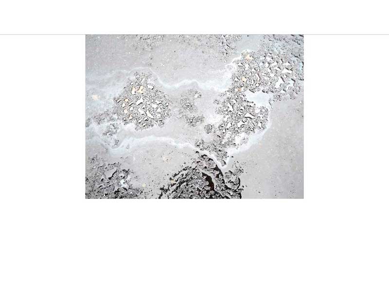 Nahaufnahme einer grauen Betonoberfläche mit unregelmäßigen Texturen und Mustern