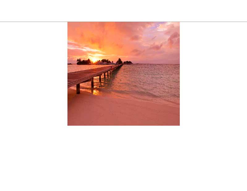 Holzsteg erstreckt sich ins Meer bei Sonnenuntergang, der Himmel ist in orange und rosa Tönen gefärbt