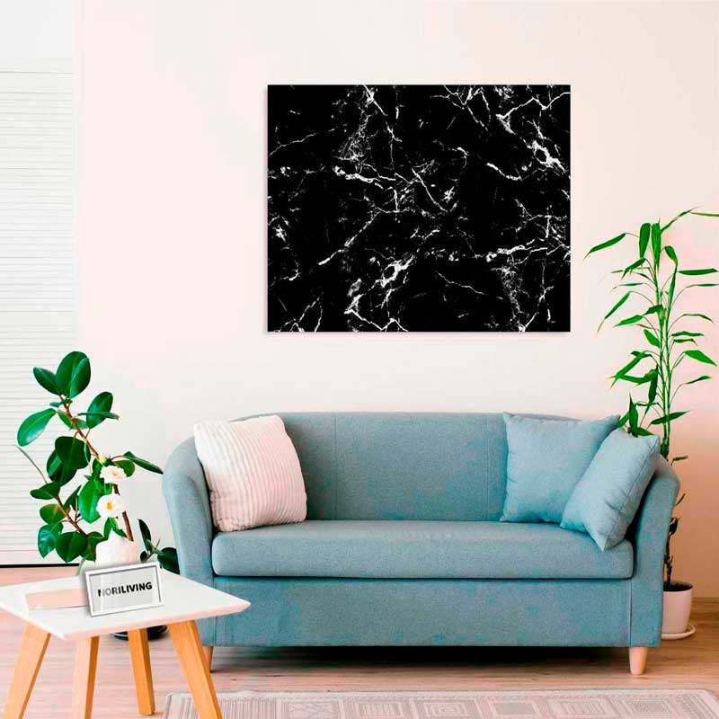 Elegantes Wohnzimmer mit einem blauen Sofa, dekoriert mit einem schwarzen Marmorbild an der Wand und einem weißen Couchtisch mit Pflanze