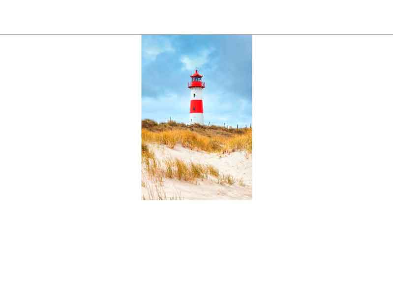 Ein roter Leuchtturm steht auf einer Düne, umgeben von Sand und Gras, unter einem blauen Himmel