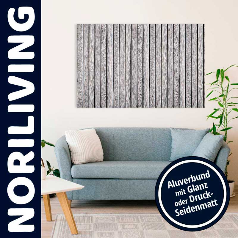 Ein stilvoll eingerichtetes Wohnzimmer mit einem blauen Sofa und einem Aluverbundbild mit vertikalem Streifenmuster an der Wand.