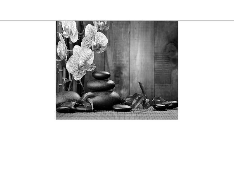 Ein Stapel glatter Steine neben Orchideen auf einem Bambusmatten-Untergrund, ideal für Entspannung und Meditation