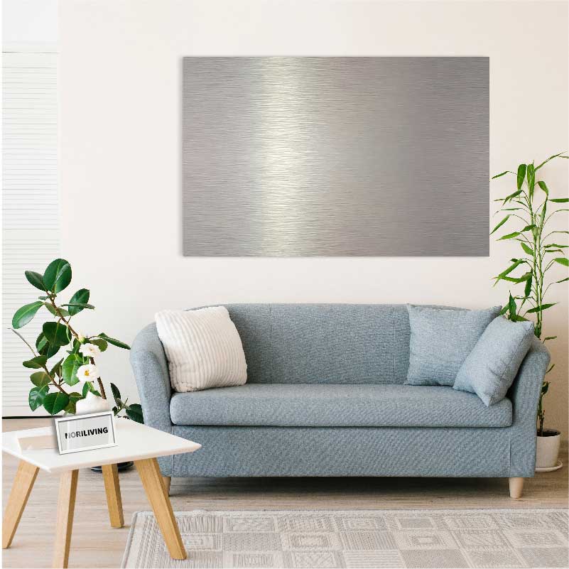 Ein modernes Wohnzimmer mit einem grauen Sofa, dekoriert mit Kissen, einem kleinen weißen Tisch und einer großen, metallischen Wandkunst im Hintergrund. Pflanzen ergänzen das elegante Design.