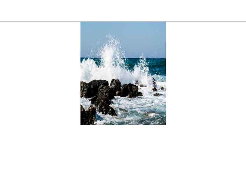 Kraftvolle Meereswellen treffen auf Felsenküste Dynamische Wellen schlagen gegen eine felsige Küste, blaues Meer im Hintergrund