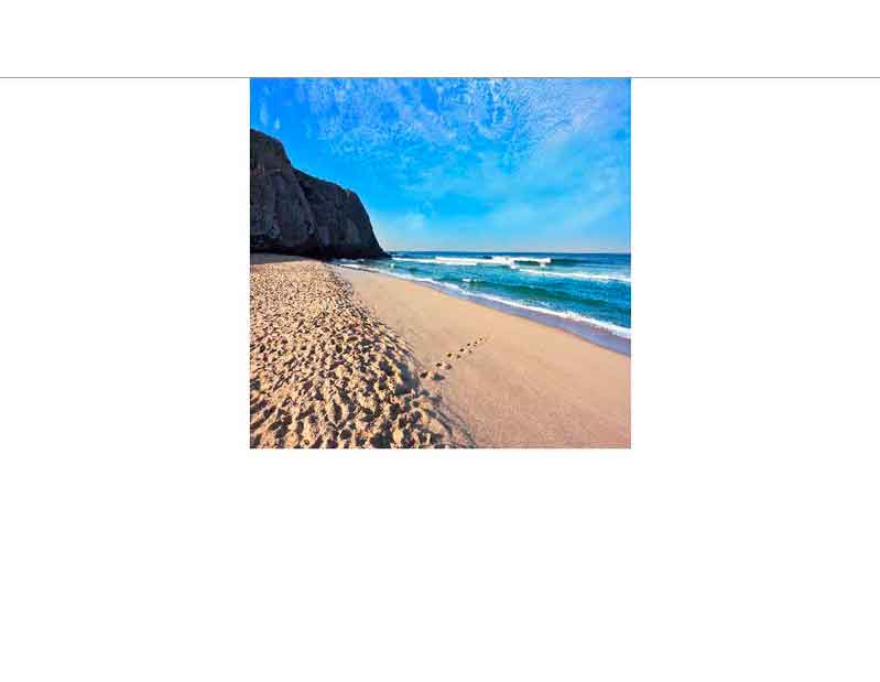 Idyllischer Sandstrand mit blauem Himmel Fußspuren im Sand an einem ruhigen Strand mit blauem Himmel und sanften Wellen
