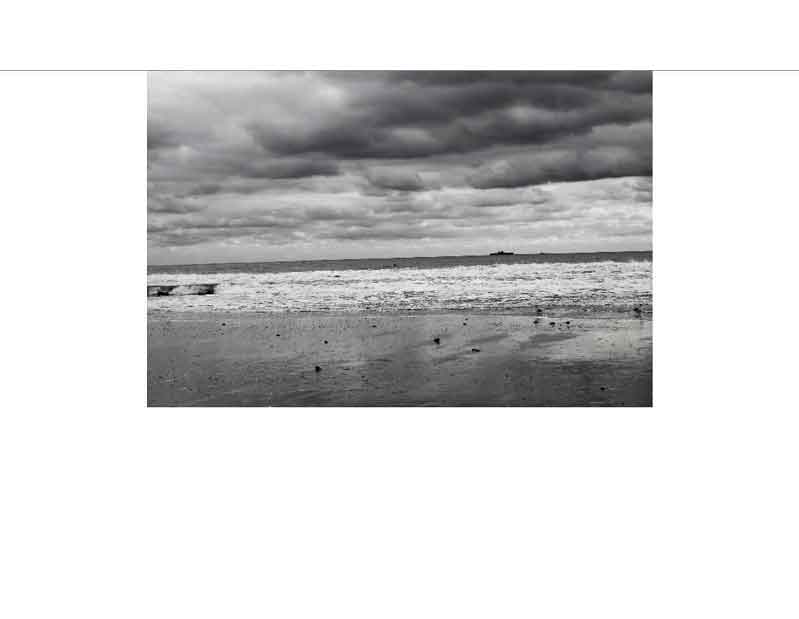 Schwarz-weiß Foto eines stürmischen Meeres mit Wolken Schwarz-weiß Bild eines stürmischen Strandes mit Wolken und Wellen