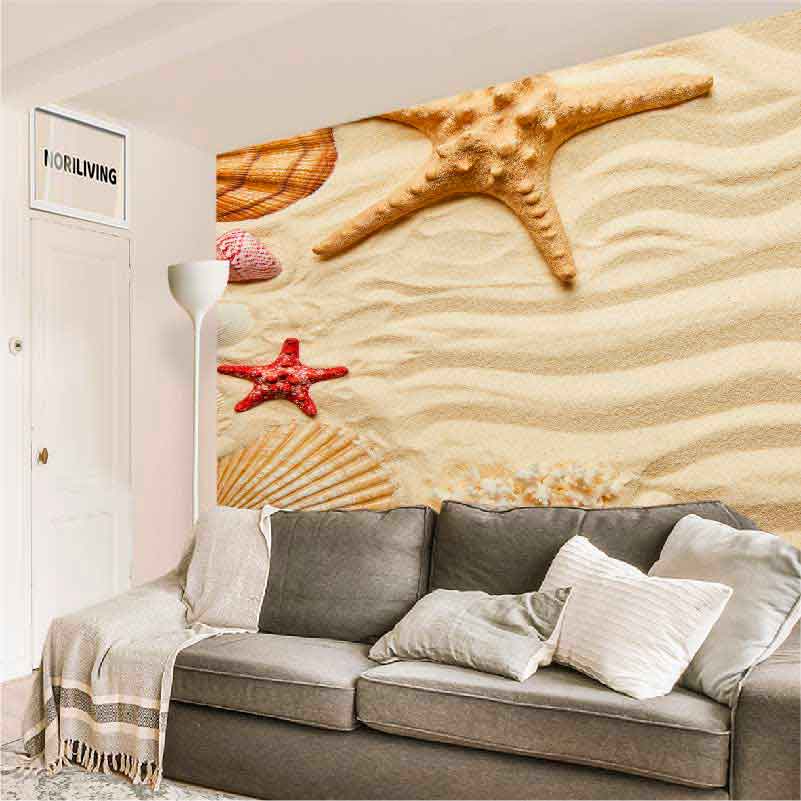 Gemütliches Wohnzimmer mit grauer Couch und farbigem Wandbild mit Sandstrand-Motiv und Seesternen.