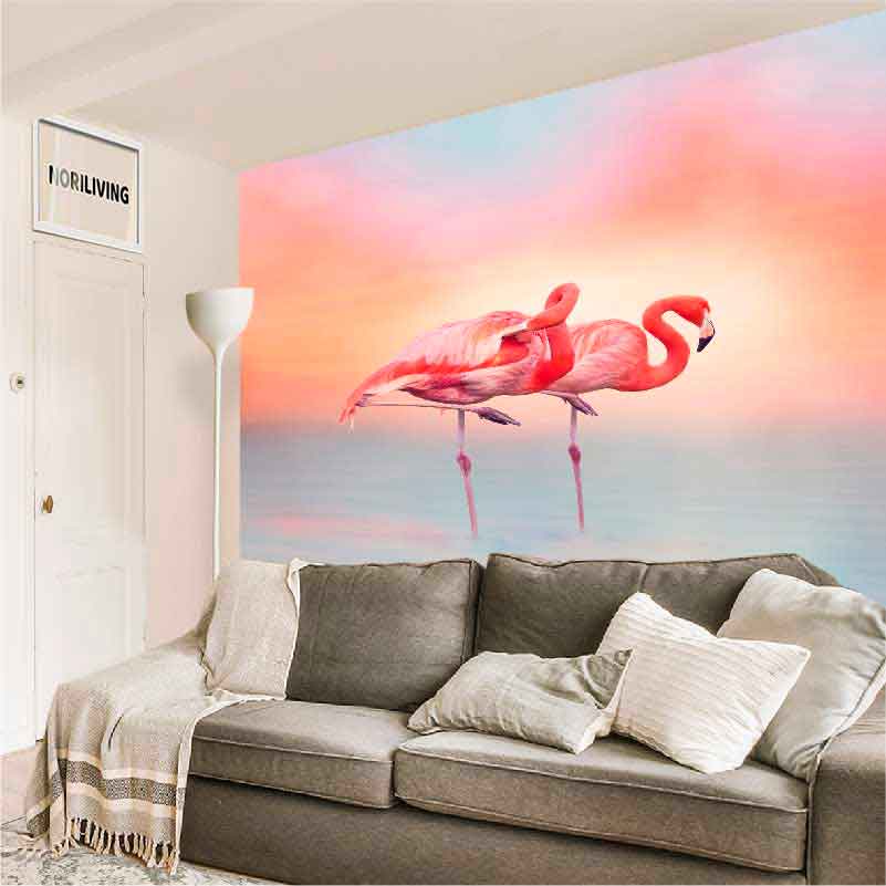 Wohnzimmer mit Flamingo-Wandbild und grauem Sofa Gemütliches Wohnzimmer mit einem großen Wandbild von zwei Flamingos vor einem pastellfarbenen Himmel, grauem Sofa und weißen Kissen
