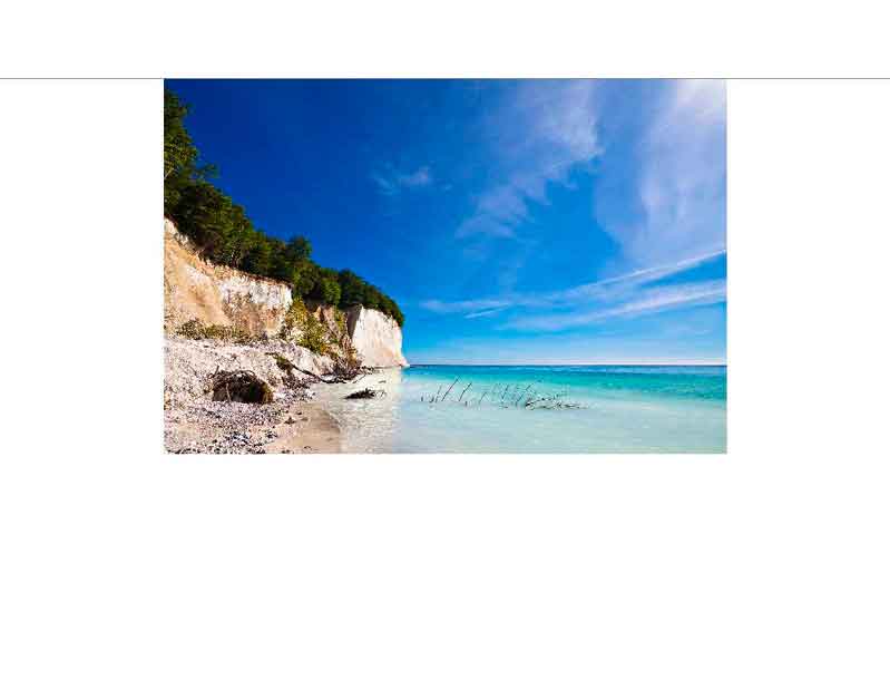 Blick auf die Kreideküste von Rügen mit blauem Himmel und klarem Wasser