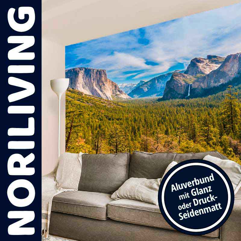 Wohnzimmer mit Noriliving Wandbild. Landschaftsmotiv von Bergen und Wäldern, Sofa im Vordergrund.