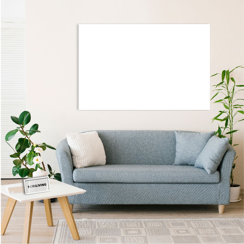 Ein stilvolles Wohnzimmer mit einem grauen Sofa, einem kleinen weißen Couchtisch und grünen Zimmerpflanzen.